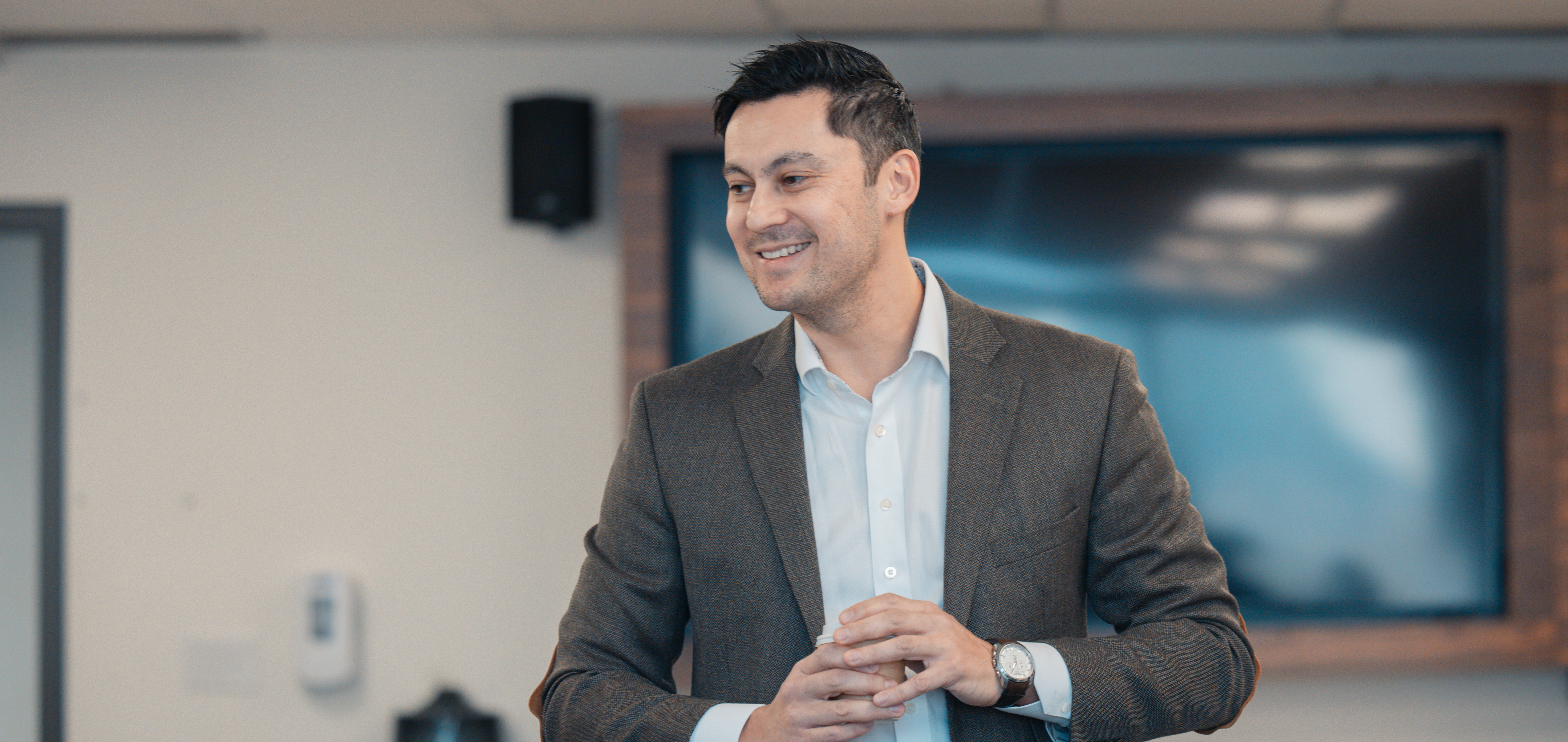 Dr. Daniel Santa Mina delivers a mock lecture wearing a blazer and a collared shirt