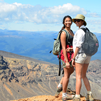 two students in backpacks on mountain