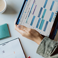 overhead view of person holding tablet and day planner