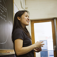 asian female student standing in front of chalkboard