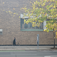 lone woman walking past warren stevens building in the fall