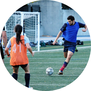 young man kicking a soccer ball on an outdoor turf field