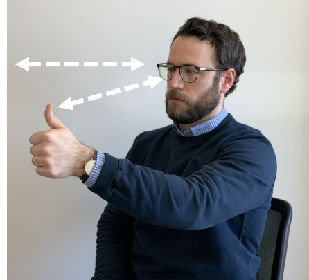 person sitting in seat with left arm and thumb raised with directional arrows to show movement