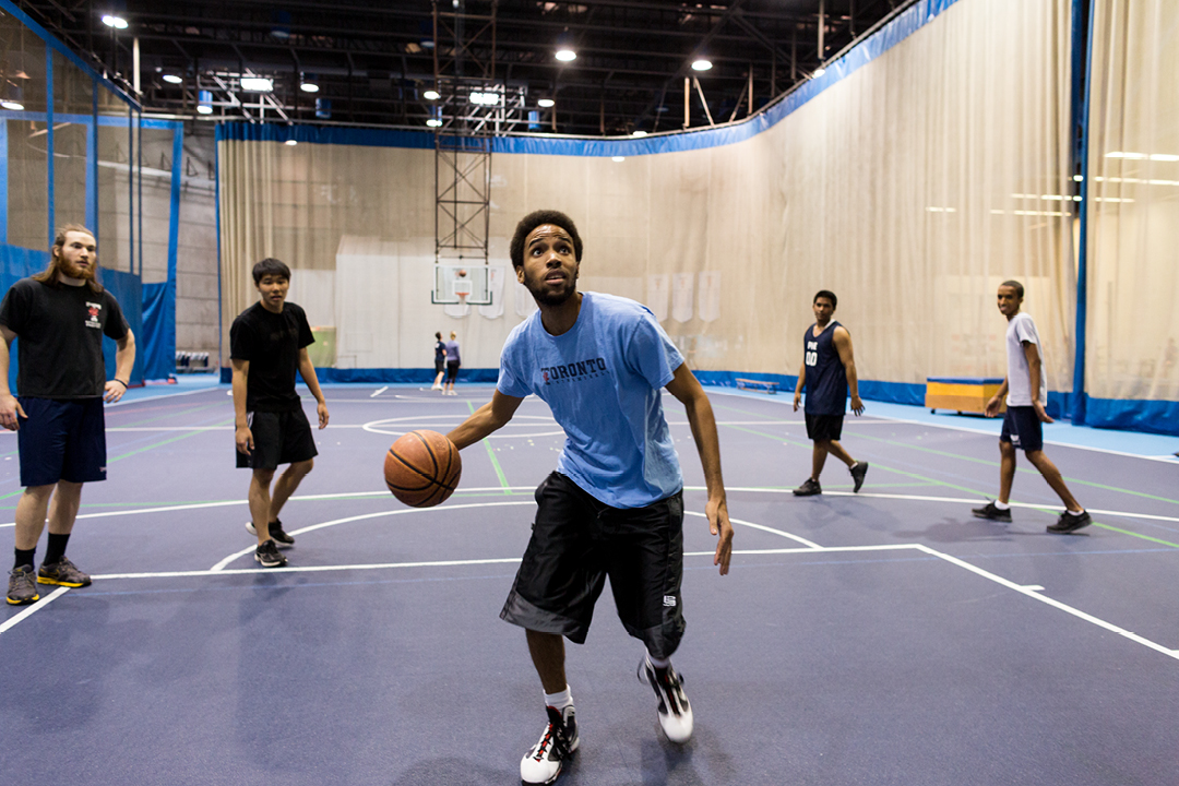 college guy playing basketball indoors