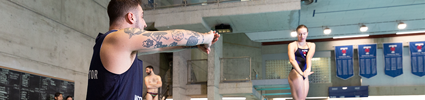 Woman preparing to dive next to a instructor