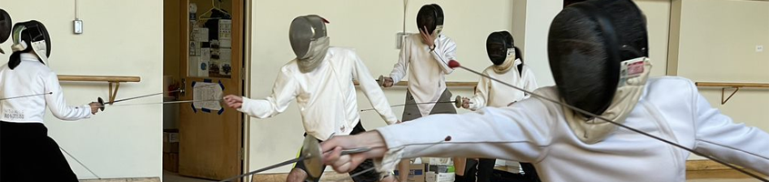 People fencing while wearing helmets