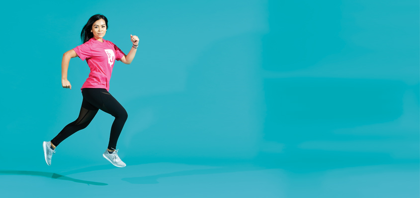 Female student jumping in MoveU t-shirt