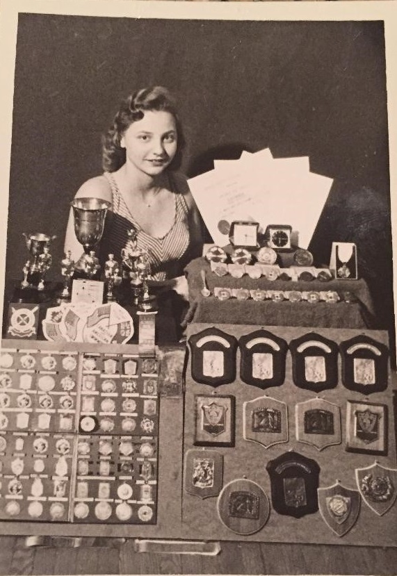 Sheila Romeiko as a child with her swimming medals and trophies