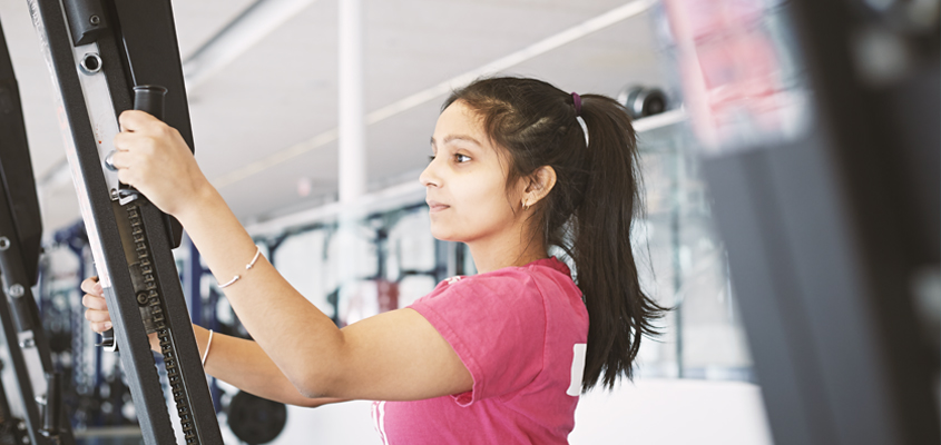 Female student using exercise machine