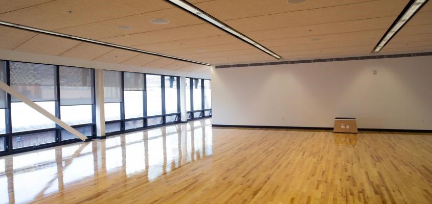Photo of Gldring Centre Fitness Studio. Large open studio with wooden floors, windows on the left side and mirrors on the right side.