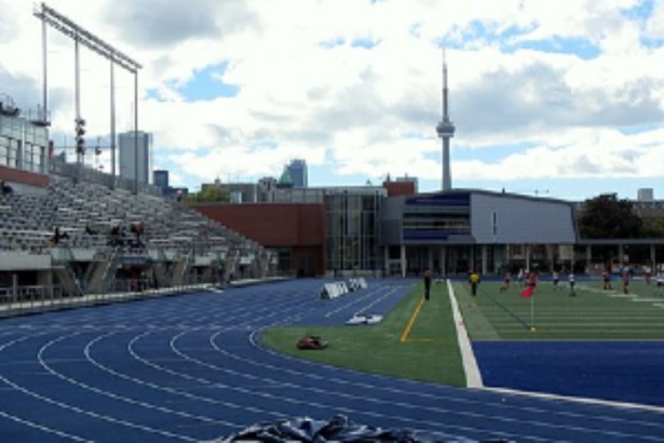 Varsity track on sunny day, scoreboard reads "Welcome Back"