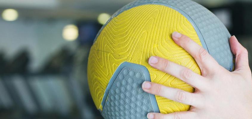 Close up photograph of hand holding medicine ball