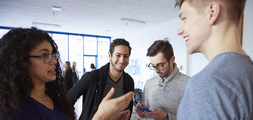 male and female students in a group chatting in student lounge