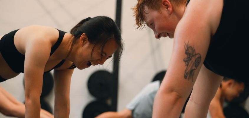 Two people in a push up plank in group fitness class.