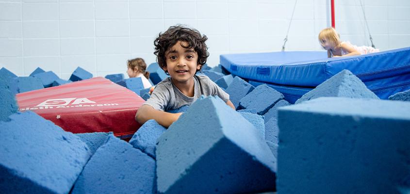 child in gymnastics foam pit