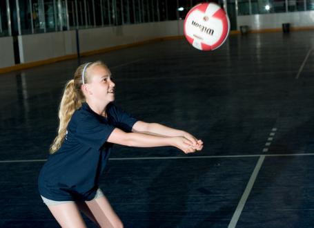 A girl bumps a volleyball