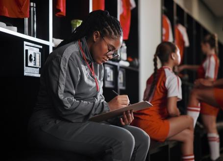 Coach taking notes in a locker room